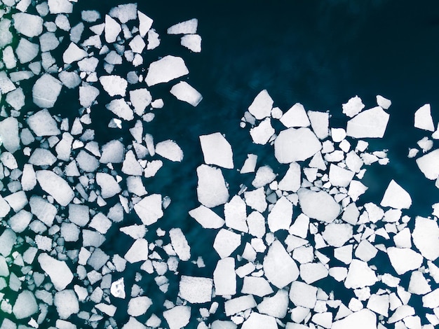 Lastre di ghiaccio sulla superficie dell'acqua del lago. Vista aerea dall'alto verso il basso. Lago Baikal, Siberia, Russia. Sfondo astratto della natura