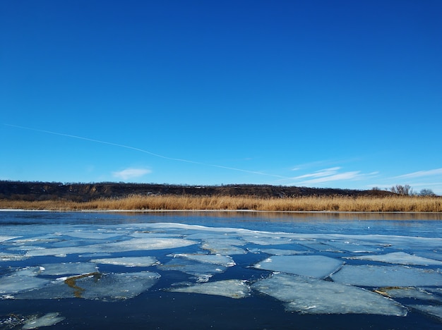 Lastroni di ghiaccio galleggiano sul fiume. Scongelare alla fine dell'inverno.