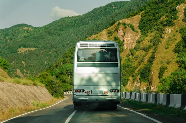 Lato posteriore del bus. Vista posteriore. Bus bianco in bianco sulla strada di montagna.