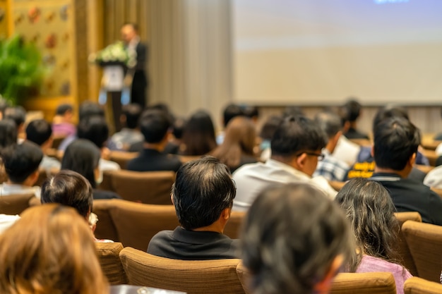 Lato posteriore del pubblico che ascolta lo Speaker con il podio sul palco nella sala delle conferenze