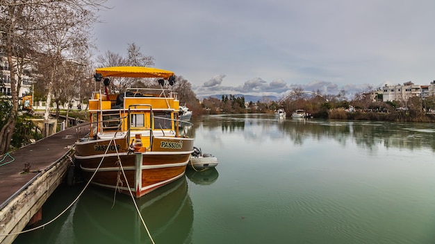 Lato Turchia 03 febbraio 2023 la barca per i viaggi turistici è ormeggiata al canale d'acqua Il piccolo yacht è legato al fiume in una piccola città turistica