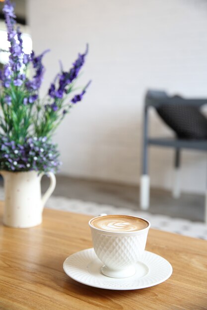 Latte al caffè su fondo in legno con fiore