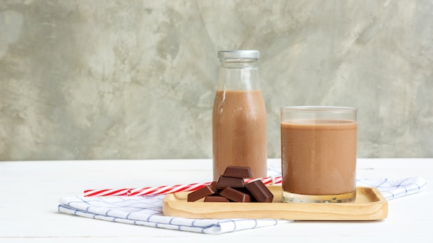 Latte al cioccolato su un tavolo di legno bianco.