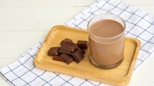 Latte al cioccolato su un tavolo di legno bianco.