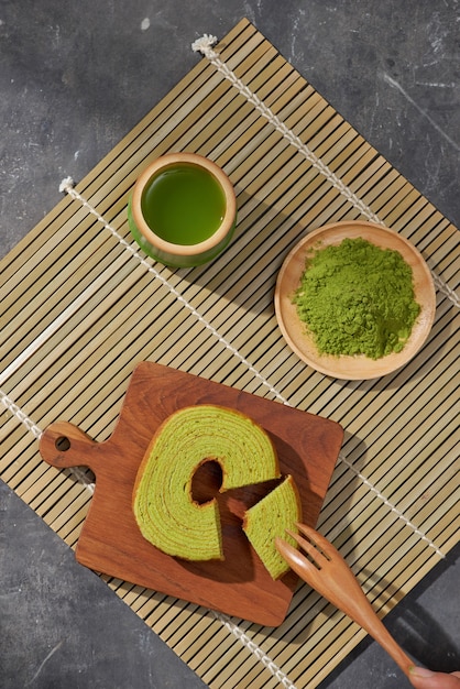 Latte al tè verde Matcha in una tazza e utensili per la cerimonia del tè con torta tedesca. Copia spazio