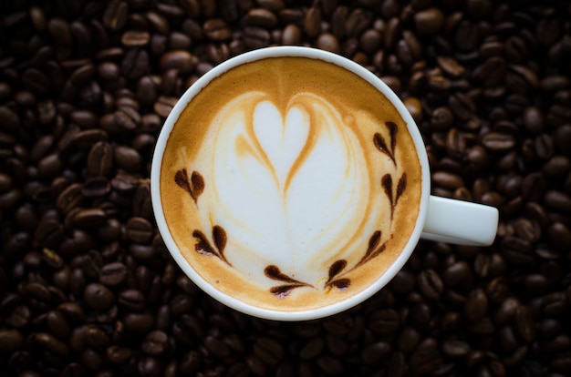 latte art caffè sullo sfondo di chicchi di caffè