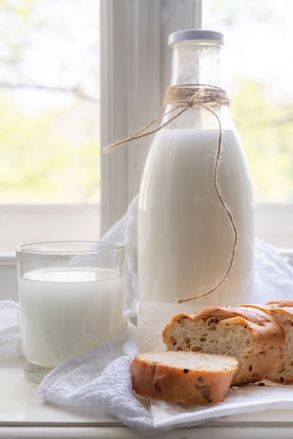 Latte crudo fresco di mucca sul davanzale, sana colazione nel villaggio, versare il latte nei bicchieri