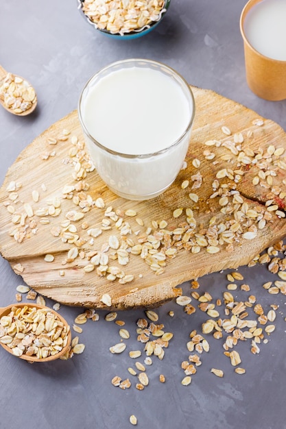 Latte d'avena Latte di avena biologico su un supporto di legno Bevanda organica sana vegana non lattiero-casearia con fiocchi di avena