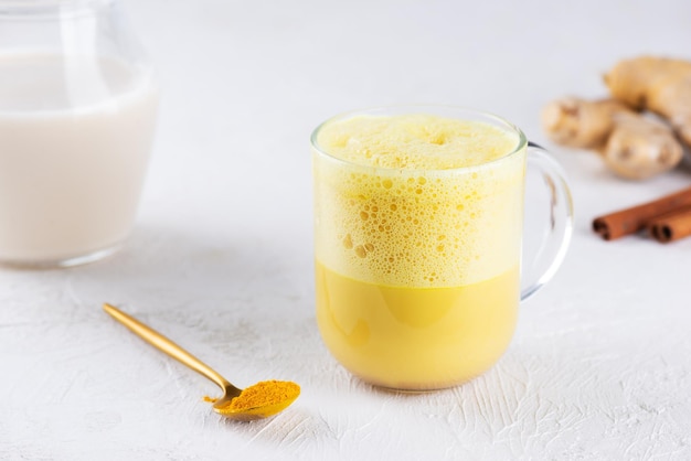 Latte d'oro alla curcuma scosso vegano da latte di mandorla, zenzero, curcuma e cannella