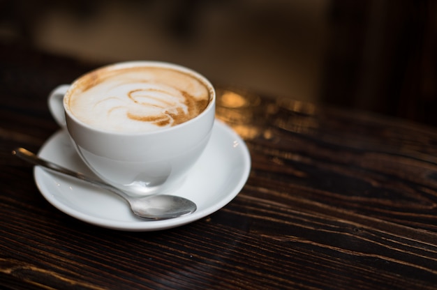 Latte della tazza di caffè su vecchia superficie di legno