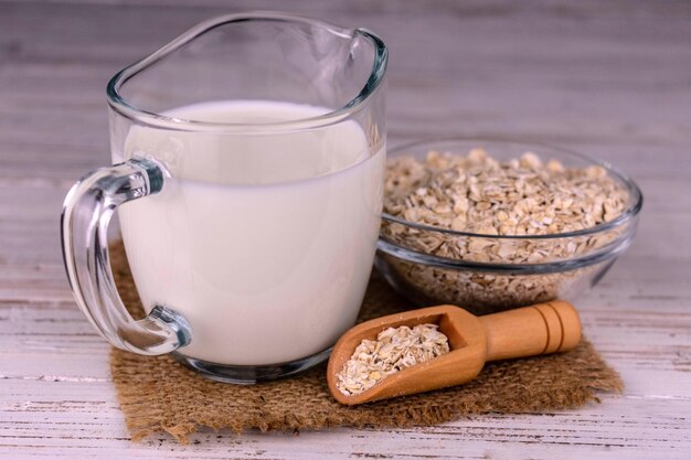 Latte di avena senza lattosio in un decanter di vetro su sfondo bianco