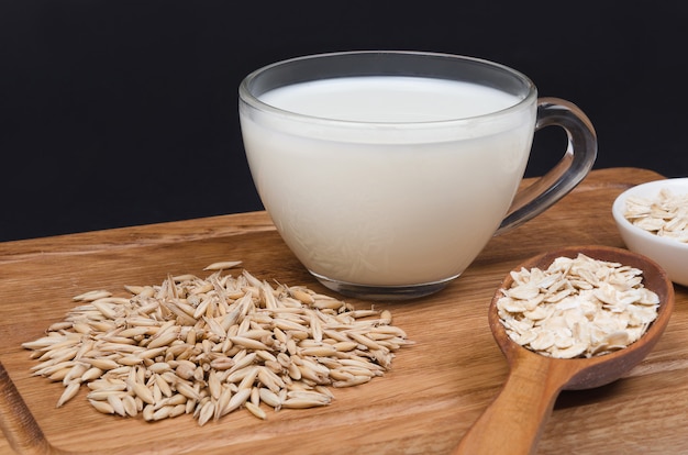 Latte di farina d'avena con semi di avena sulla tavola di legno