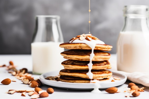 Latte di mandorle che spruzza su una pila di pancake