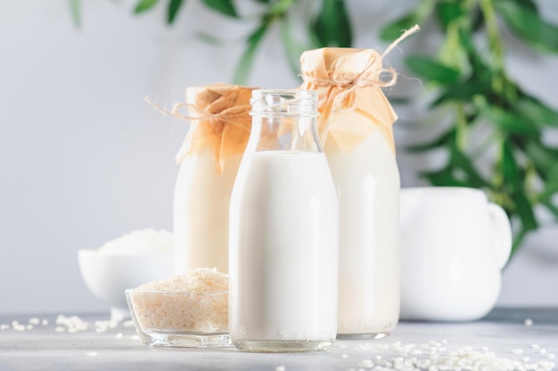 Latte di riso in bottiglia sfondo grigio primo piano Latte alternativo non caseario Cibo e bevande vegetariani sani