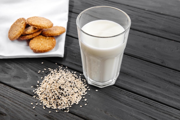 Latte di semi di sesamo in un bicchiere semi di sesamo bianchi sul tavolo dieta cruda l'alternativa del latte