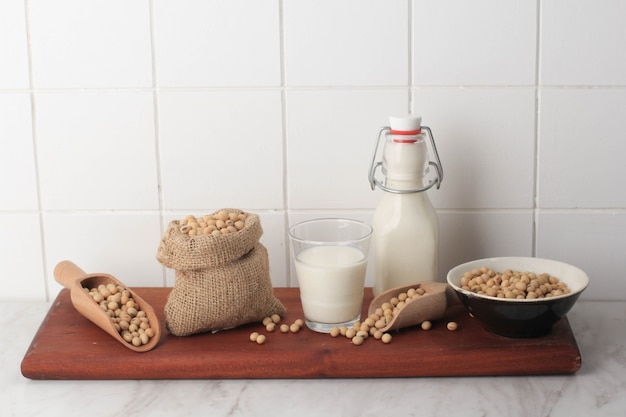 Latte di soia e cereali su un tavolo di legno e uno sfondo di cucina rustica. Concetto di latte alternativo. Vista frontale