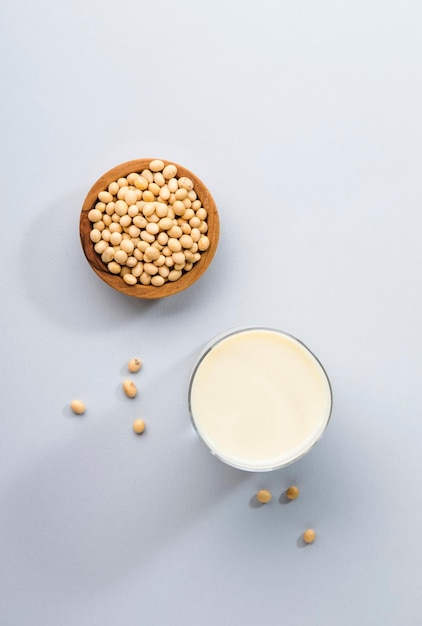 Latte di soia e fagioli di soia su sfondo grigio della cucina del tavolo Concetto di latte non caseario Bevanda vegana Luce dura Spazio per la copia