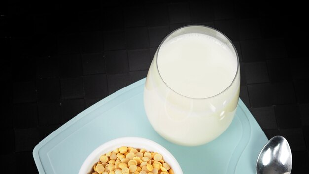 latte di soia senza zucchero aggiunto in un bicchiere su un piatto di plastica di colore verde mat closeup immagini