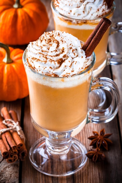 Latte di spezie di zucca con panna montata sul tavolo di legno