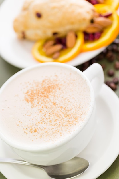 Latte di tè Chai con focaccina fresca all'arancia e mirtillo rosso per colazione.