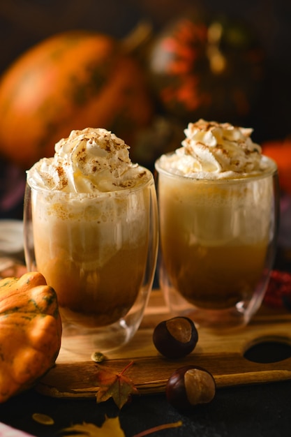 Latte di zucca con panna montata in bicchieri nello stile del cibo scuro. Bevanda piccante autunnale per Halloween o il Ringraziamento. messa a fuoco selettiva