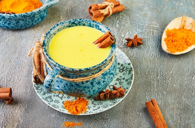 Latte dorato con curcuma, bastoncini di cannella, curcuma e anice