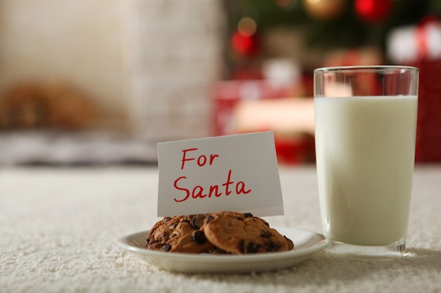 Latte e biscotti di natale per babbo natale sul tavolo sfondo di natale