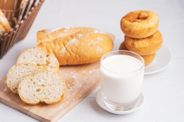 Latte e pane su un tavolo di legno bianco, copia spazio, colazione