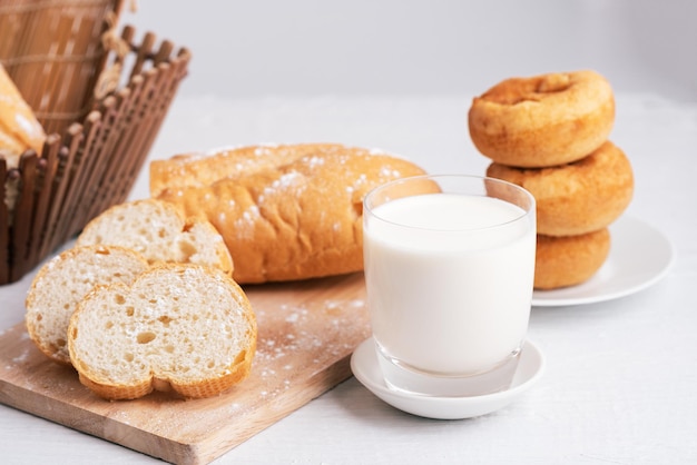 Latte e pane su un tavolo di legno bianco, copia spazio, colazione
