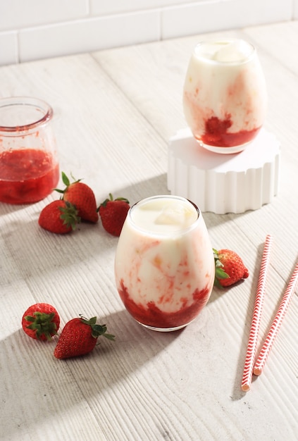 Latte fresco alla fragola coreana con salsa di composta di fragole fatta in casa su sfondo bianco, copia spazio per il testo