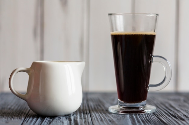 Latte glass con caffè scuro e brocca