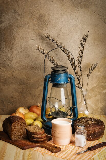 latte in ceramica pane di segale sale verdure giusquiamo ramo e lanterna a cherosene