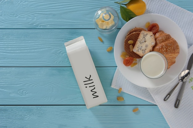 Latte in scatola di cartone e cottura su fondo di legno blu, vista dall'alto. concetto di alimentazione sana