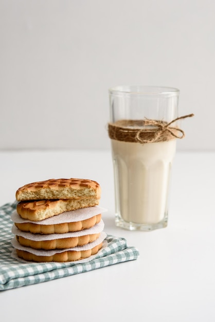 Latte in un bicchiere e biscotti sul tavolo