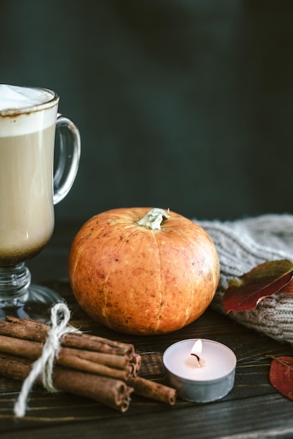 Latte piccante della zucca su una tavola di legno con un maglione