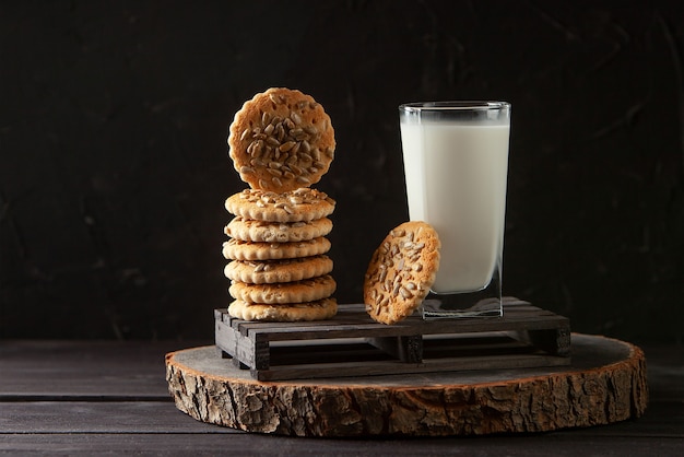 Latte sano fresco e biscotti fatti in casa su un tavolo di legno scuro