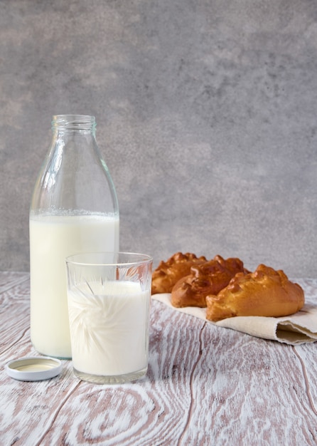 Latte vaccino fresco e torte fatte in casa sulla tavola di legno