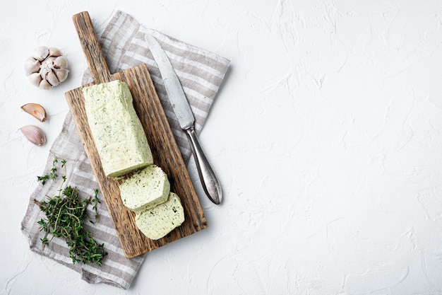 Latticini burro verde con erbe aromatiche, sul tavolo di pietra bianca