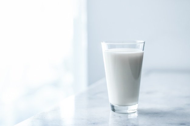 Latticini nutrizione sana e concetto di colazione giornata mondiale del latte bicchiere pieno sul tavolo di marmo