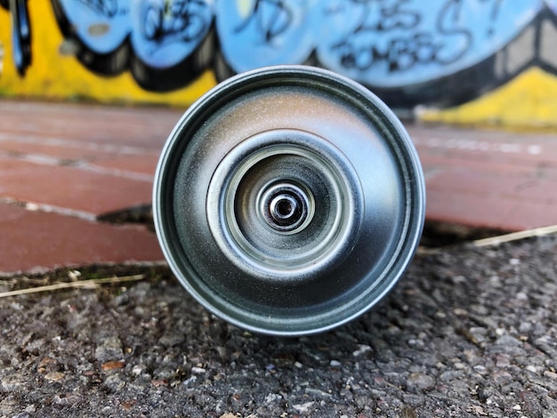 Lattina di aerosol sulla strada contro il muro dei graffiti