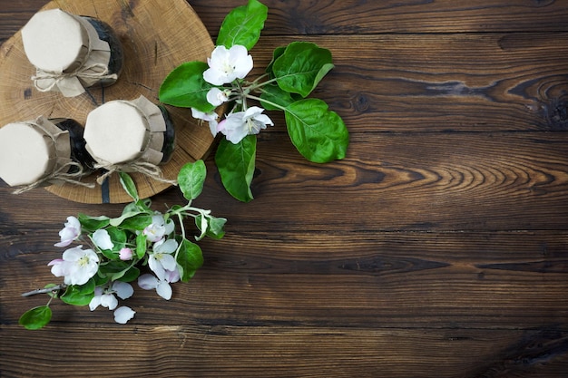 Lattine con coperchi artigianali stanno su un albero segato su un tavolo di legno