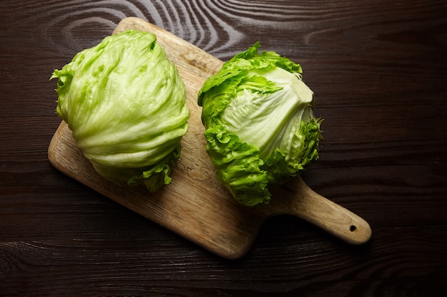 Lattuga di iceberg sul tagliere sulla tavola di legno