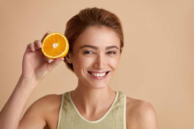 Laughing Girl Hold Fette di Orange Happy Woman Vitamina consigliata per la pelle