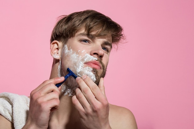 Laurea con crema da barba o schiuma sulla pelle del viso