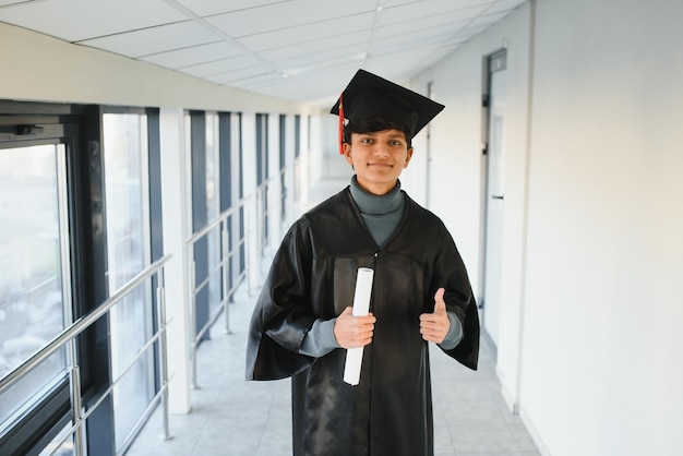 Laureato indiano emotivo in bagliore di laurea e diploma.