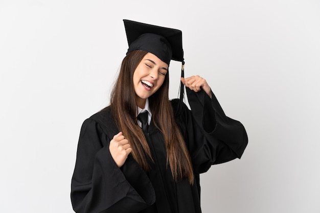 Laureato universitario brasiliano dell'adolescente sopra fondo bianco isolato che celebra una vittoria