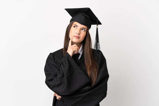 Laureato universitario brasiliano dell'adolescente sopra fondo bianco isolato che ha dubbi mentre osserva in su