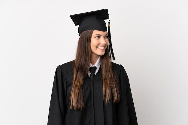 Laureato universitario brasiliano dell'adolescente sopra fondo bianco isolato che osserva lato