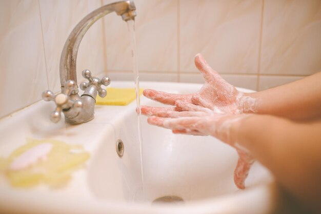 Lavaggio a mano con acqua e sapone per prevenire il coronavirus Elaborazione di foto vintage per lavaggio a mano