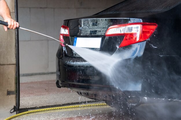 Lavaggio auto. Pulizia auto con acqua ad alta pressione e schiuma. Trasporti